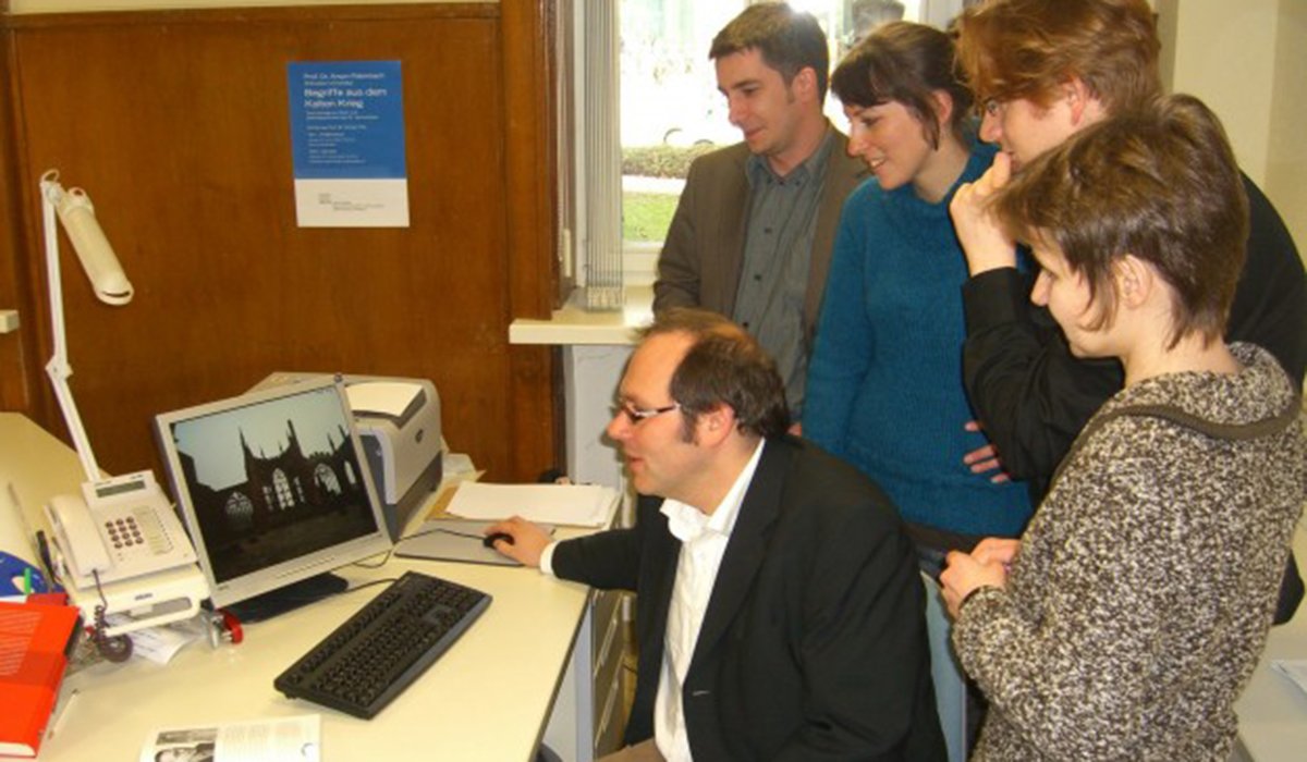  People stand around a computer