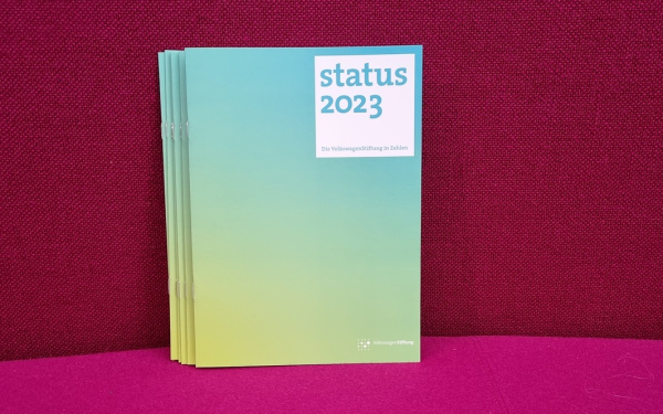 Broschüre mit Aufdruck "status 2023" vor rotem Hintergrund