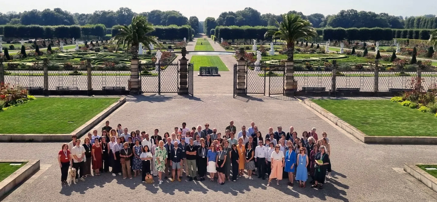 Eine Gruppe Erwachsener vor einem imposanten Garten