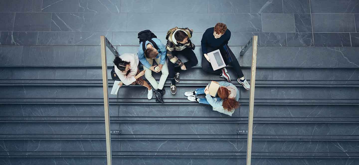 Eine gruppe junger Menschen sitzt auf einer Treppe.
