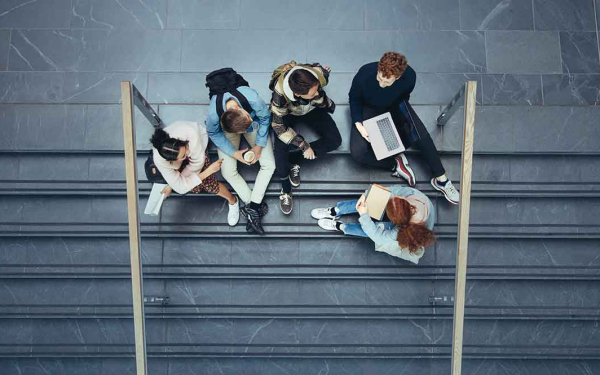 Eine gruppe junger Menschen sitzt auf einer Treppe.