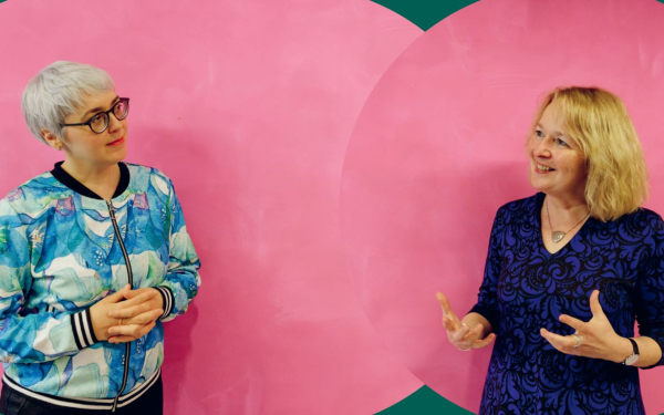 zwei Frauen vor einer rosafarbenen Wand