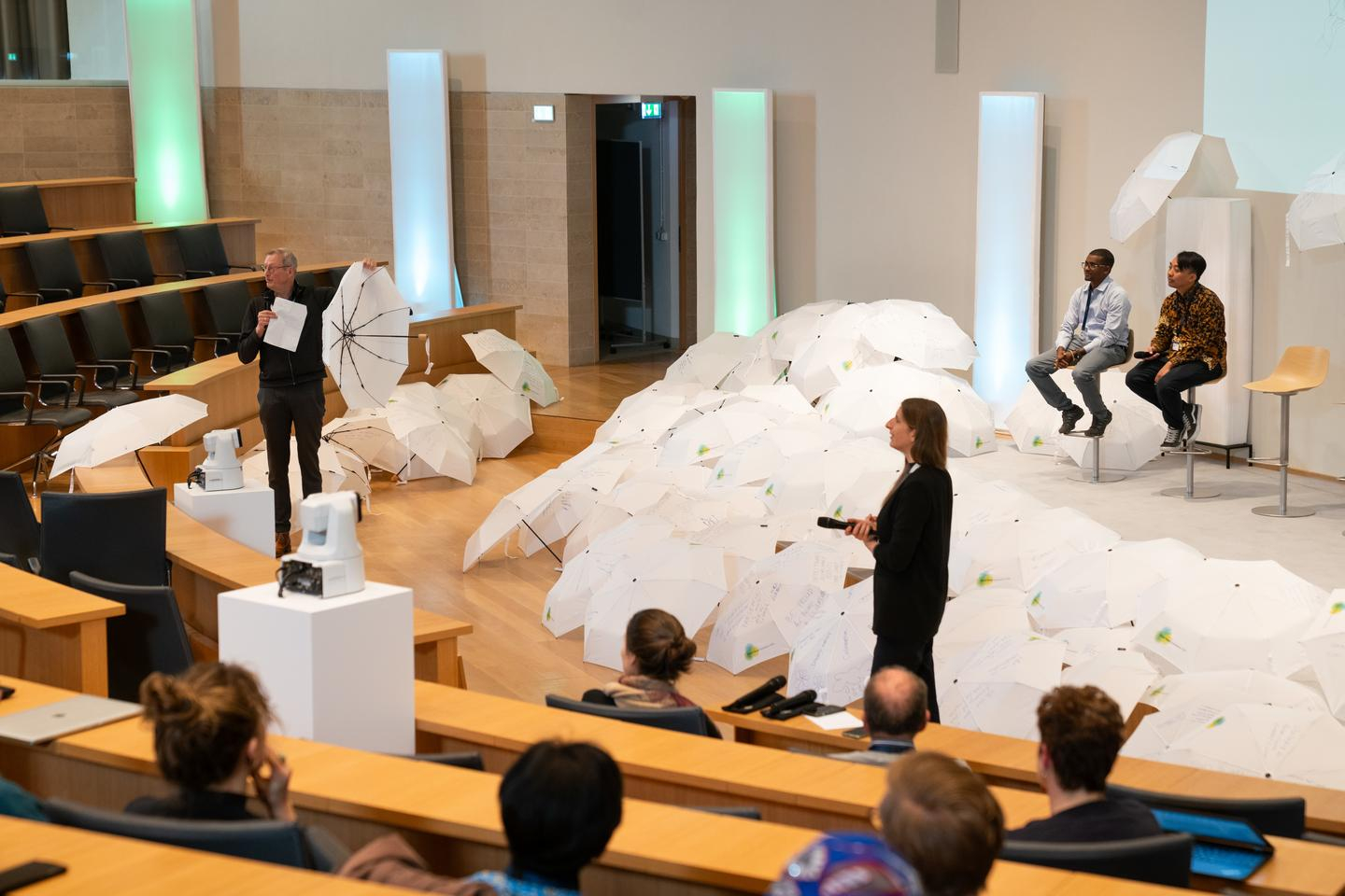 Auditorium mit vielen weißen, beschriebenen Regenschirmen