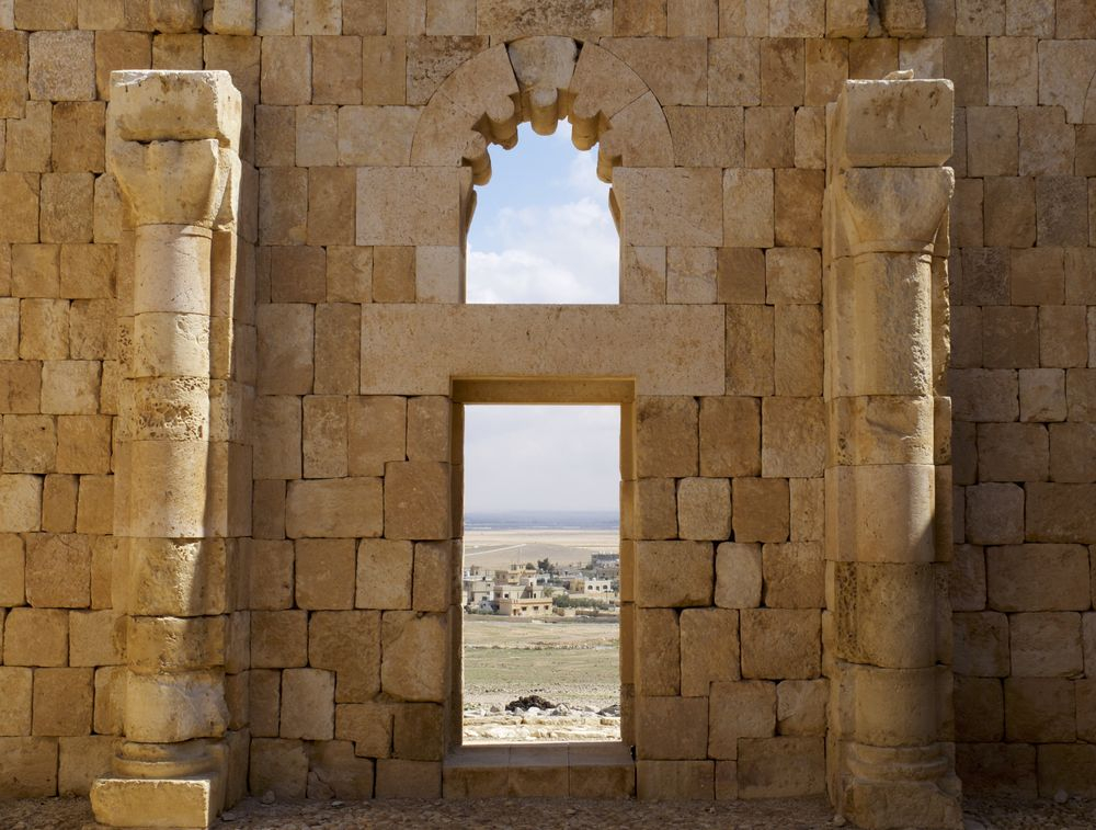 Blick durch ein Fenster in altem Mauerwerk, rechts und links vom Fenster einfache Säulen