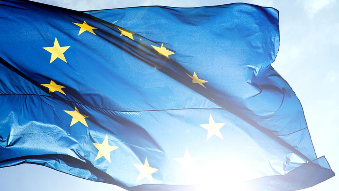 Die Flagge Europas weht vor blauem Himmel.