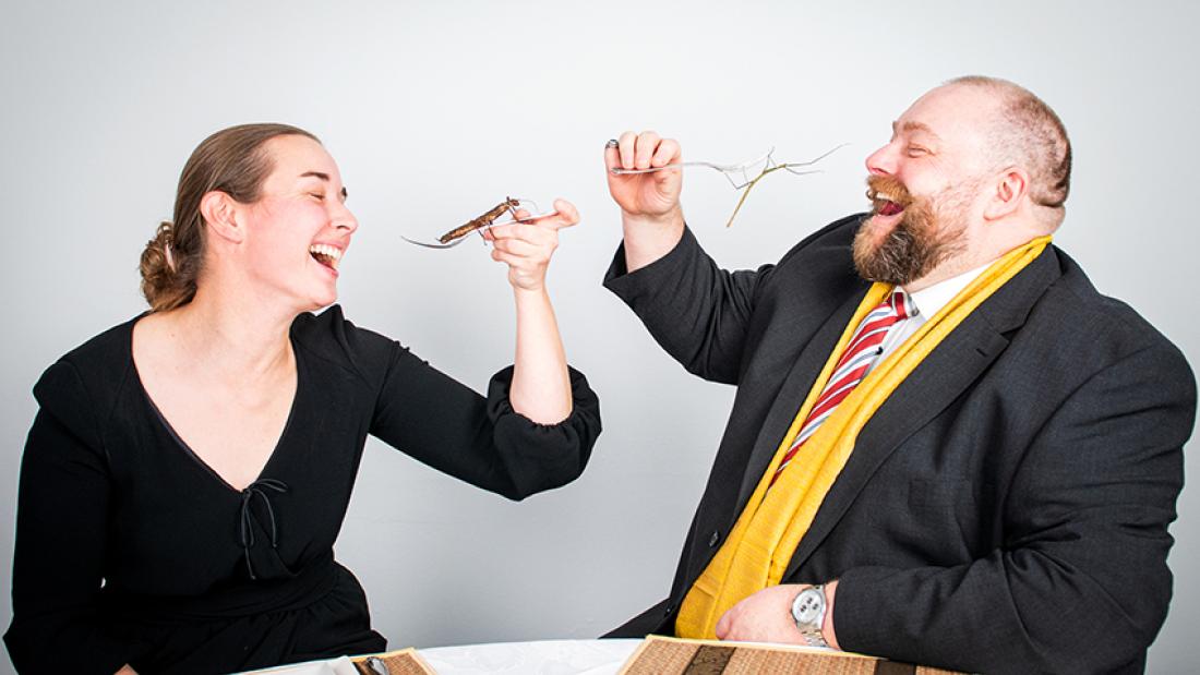 Madeleine Plötz und Nils Grabowski tun so, als würden sie Insekten essen.